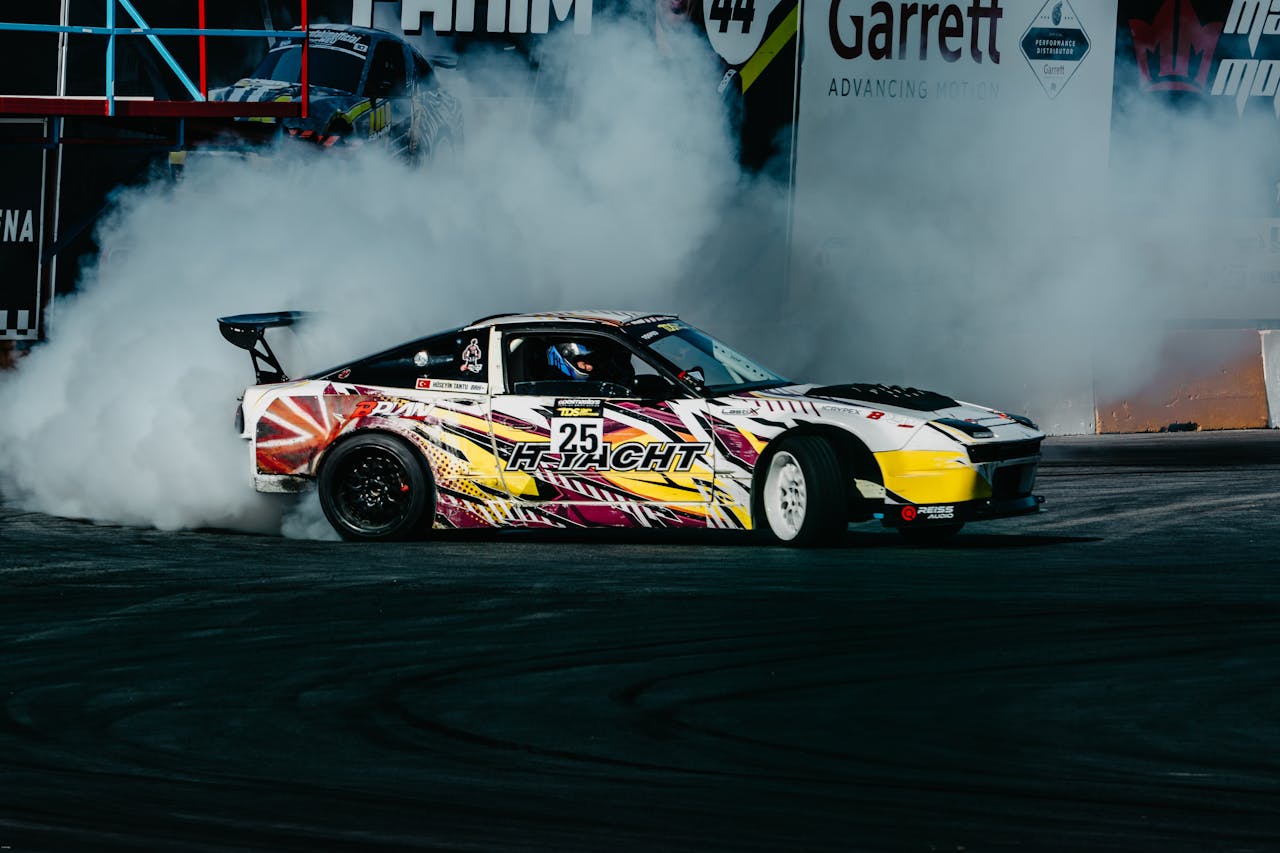Exciting image of a colorful car performing a drift amidst thick smoke at a motorsport event.